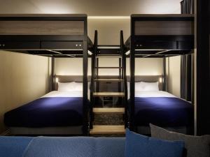 two beds in a room with two bunk beds at Minn Sapporo Odori W14 in Sapporo