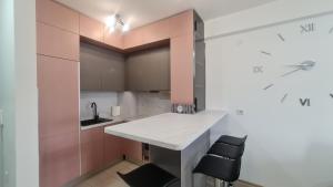 a small kitchen with a white counter and black chairs at Vivo in Jagodina