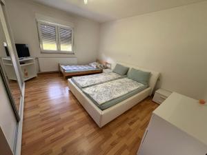 a small room with two beds and a television at Sobe DANA Banja Vrućica in Teslić