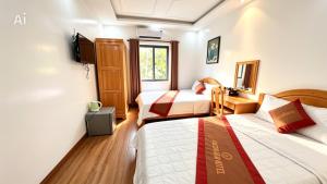 a hotel room with two beds and a tv at New Conson Hotel in Con Dao +5 photos