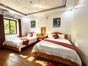 a bedroom with two beds and a window at New Conson Hotel in Con Dao