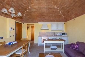 a kitchen and living room with a brick ceiling at Appartamento Rosmarino in Lajatico