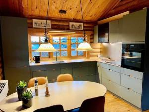 a kitchen with a table and chairs and lights at 30118-Odder-Pouli-Nielsensvej-27 in Odder