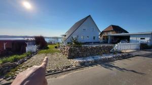 a persons index finger pointing at a white house at Ferienwohnung Seeblick in Klein Upahl