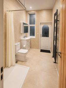 a bathroom with a toilet and a sink and a shower at SidemerseyLivings - Step-Free 4BR Home, Ground Floor Bed & Bath, Private Gated Parking in Liverpool