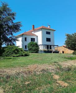 a large white house on a grass field at VILLA CLEMENTINE in Aignan