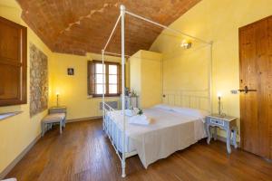 a bedroom with a bed in a room with yellow walls at Appartamento Rosmarino in Lajatico +37 photos