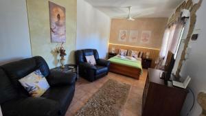 a living room with a couch and a bed at Secluded Garden Studio in Tala