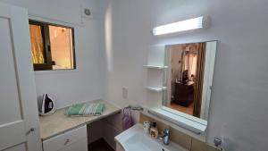 a bathroom with a sink and a mirror at Secluded Garden Studio in Tala +11 photos