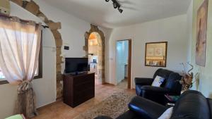 a living room with a couch and a tv at Secluded Garden Studio in Tala