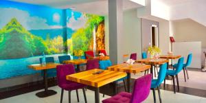a dining room with wooden tables and purple chairs at Rakovica Resort in Sarajevo