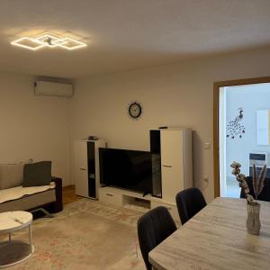 a living room with a television and a table with chairs at Villa BESA - BA Debar in Debar
