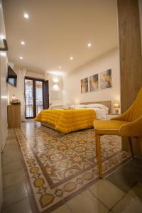a large bedroom with a yellow bed and a rug at Athenèa Smart Rooms - Atenea Collection in Agrigento