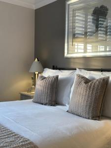 a bedroom with a bed with white sheets and pillows at The Old Bell B&B in Grimston