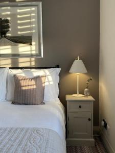a bedroom with a bed and a lamp on a night stand at The Old Bell B&B in Grimston