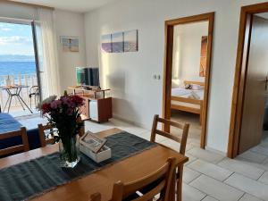 a living room with a table with a vase of flowers at Apartments Vujic in Mirce +28 photos