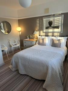 a bedroom with a large white bed and a chair at The Old Bell B&B in Grimston