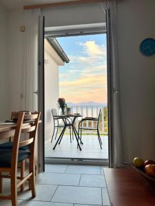 a room with a door open to a balcony with a table at Apartments Vujic in Mirce