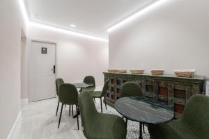 a room with green chairs and tables and a counter at Rosales Suites in Madrid