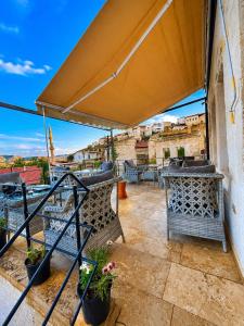a patio with chairs and tables on a balcony at Zuwinasa House Hotel in Avanos