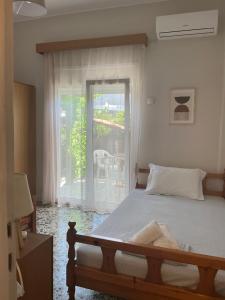 a bedroom with a bed and a large window at Niki Seaside Apartments in Platamonas