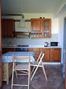 a kitchen with wooden cabinets and a table and chairs at Il Borghetto in Castano Primo +3 photos