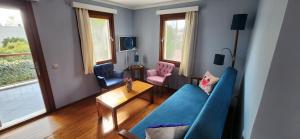 a living room with a blue couch and two pink chairs at Bodrum Stone House Hotel in Bodrum City