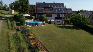 an aerial view of a house with a swimming pool in the yard at Heim Lisse in Dietenhofen
