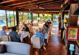 a group of people sitting at tables in a restaurant at Bodrum Stone House Hotel in Bodrum City