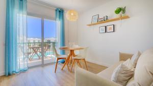 a living room with a table and chairs and a balcony at NEW AVATEA Parque Natural, piscinas y tennis in Corralejo
