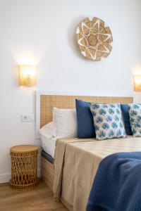a bedroom with a bed with blue and white pillows at NEW AVATEA Parque Natural, piscinas y tennis in Corralejo +33 photos