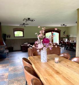 a vase of flowers sitting on a wooden table at 'Onze Knoerishoeve' in Odiliapeel