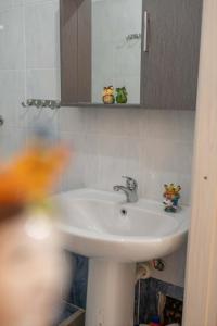 a bathroom with a white sink and a mirror at Artemide B&B in Caltagirone