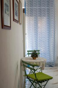 a table with a green chair and a table with a plant on it at Artemide B&B in Caltagirone +22 photos