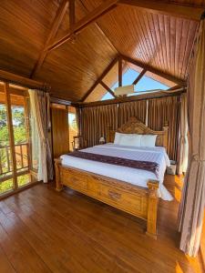 a bedroom with a large bed with a wooden ceiling at The BENAWAH Villa in Tegalalang +59 photos