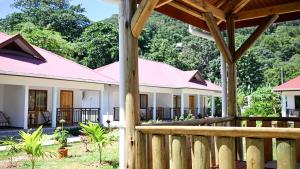 a home with a wooden fence and a porch at La Maison Figaro Guest House - Spacious Island Stay in La Digue in La Réunion