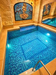 a large swimming pool with blue water in a room at Zuwinasa House Hotel in Avanos