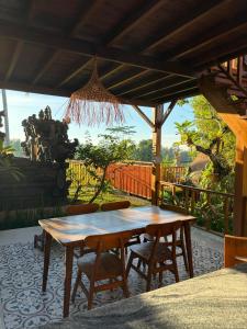 a wooden table and chairs on a patio at The BENAWAH Villa in Tegalalang