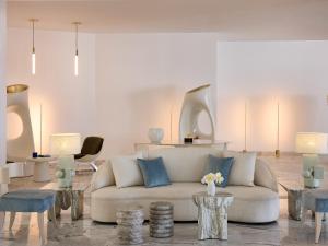 a living room with a white couch and tables at Creta Palace, A Resort to Live in Rethymno