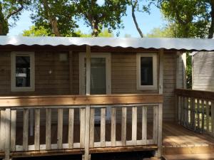 a cabin with a porch on a deck at Sweet-Mobilhome21 in Fouesnant