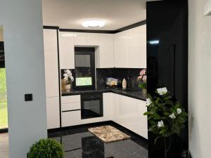 a kitchen with white cabinets and black counter tops at EMRAH RIVER UNA in Bihać