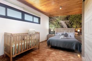 a bedroom with a crib and a large window at El Alpendre in Moya