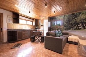 a living room with a couch and a kitchen at El Alpendre in Moya