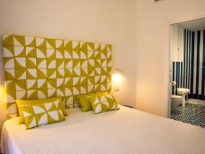 a bedroom with a large bed with yellow pillows at Hotel Boutique Ideal in Forio d'Ischia