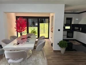 a dining room and kitchen with a white table and chairs at EMRAH RIVER UNA in Bihać