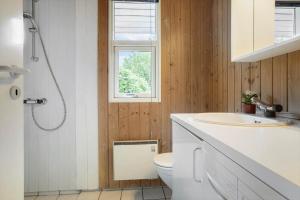 a bathroom with a sink and a toilet and a window at 30586-Odder-Tvaeragervej-7 in Odder +16 photos