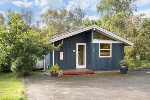 a blue tiny house with a porch and a porch at 30586-Odder-Tvaeragervej-7 in Odder