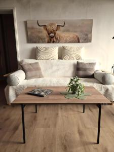 a living room with a couch with a bull painting on the wall at Fewo Schwarzwald Von Oben - Kniebis in Freudenstadt
