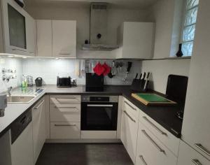a kitchen with white cabinets and a black counter top at Fewo Schwarzwald Von Oben - Kniebis in Freudenstadt