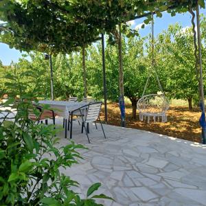 a patio with a table and chairs and a swing at Apartman Katić - Rental Home in Stolac